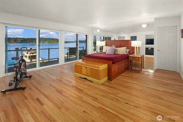 a spacious bedroom with a bed and wooden floor