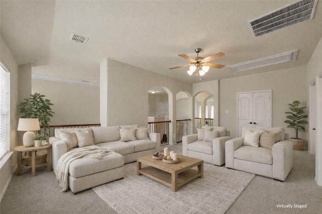5143 Stream Crest Way Fairview, TX 75069 - Photo 22 of 35 Living room with a ceiling fan, carpet, and arched walkways
