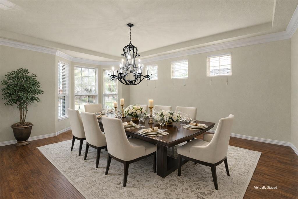 5143 Stream Crest Way Fairview, TX 75069 - Photo 5 of 35 Dining area with a tray ceiling, hanging lights, dark wood-style flooring, healthy amount of natural light, and crown molding