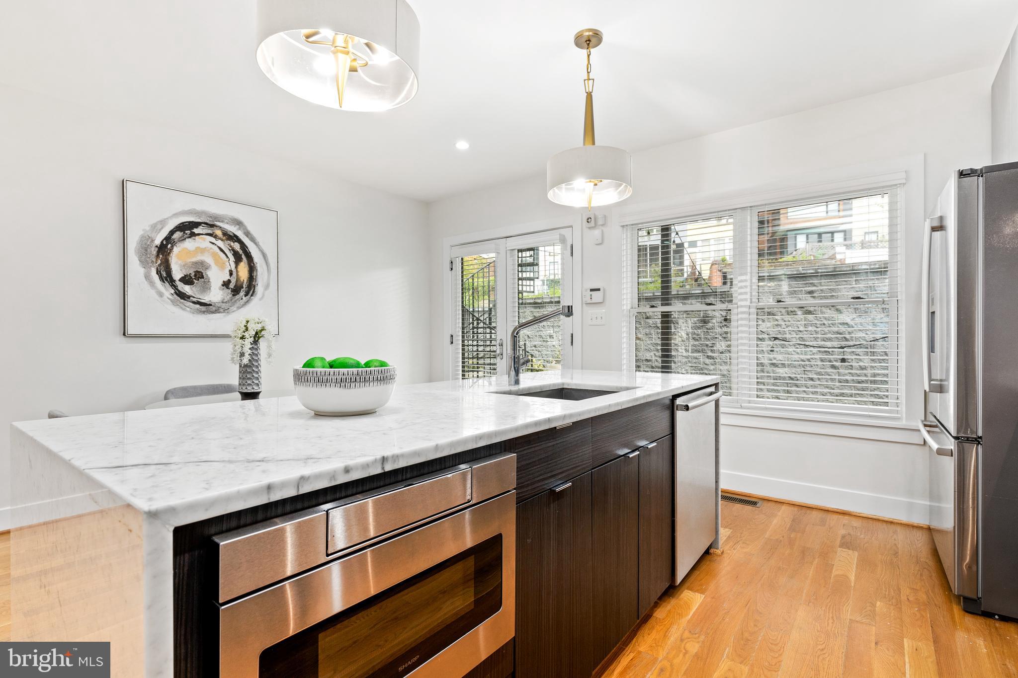 1337 Spring Road Northwest, Unit 1 Washington, DC 20010 - Photo 11 of 39 a kitchen with a table and a chandelier