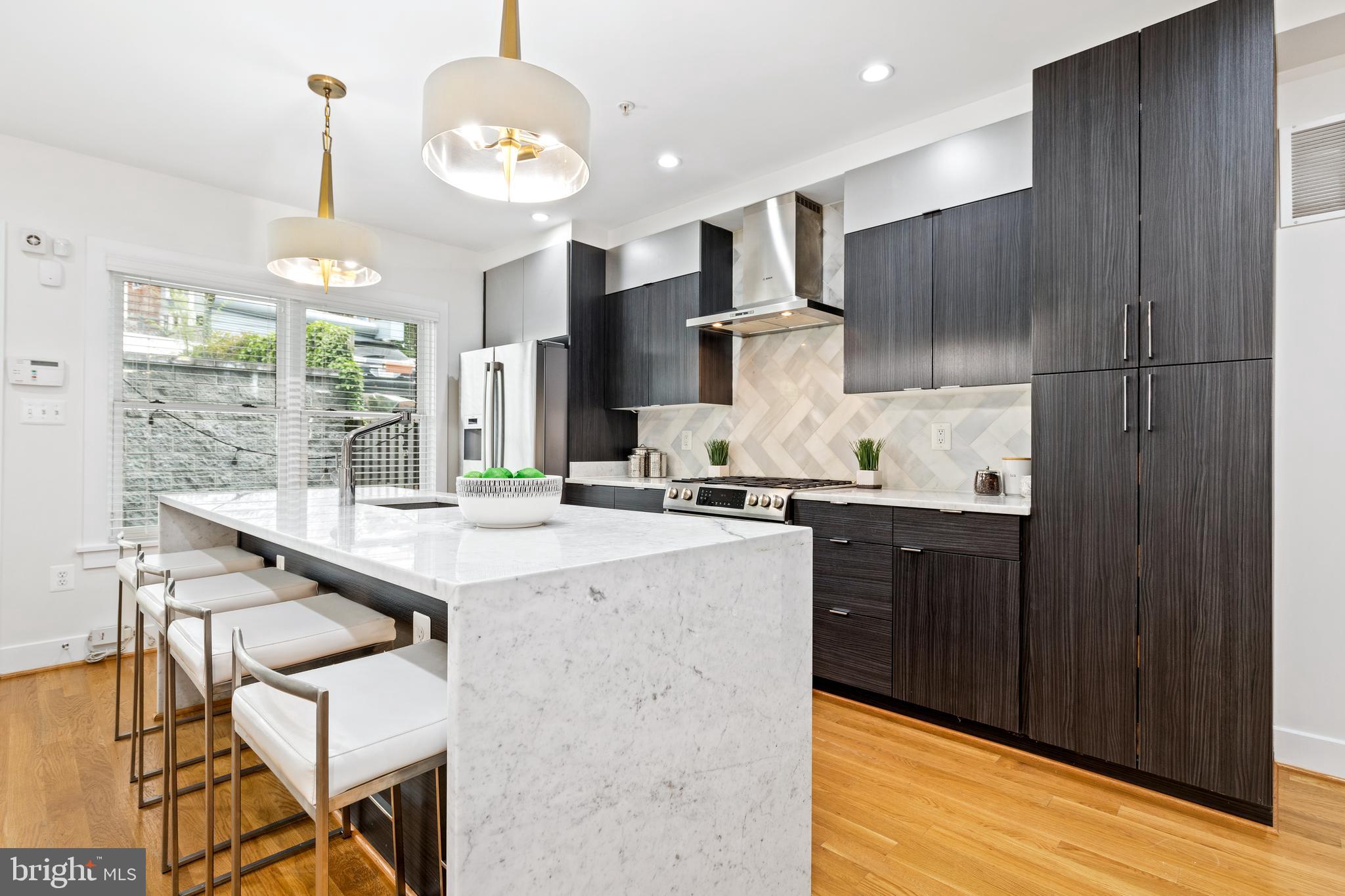 1337 Spring Road Northwest, Unit 1 Washington, DC 20010 - Photo 12 of 39 a kitchen with stainless steel appliances kitchen island granite countertop a sink and cabinets