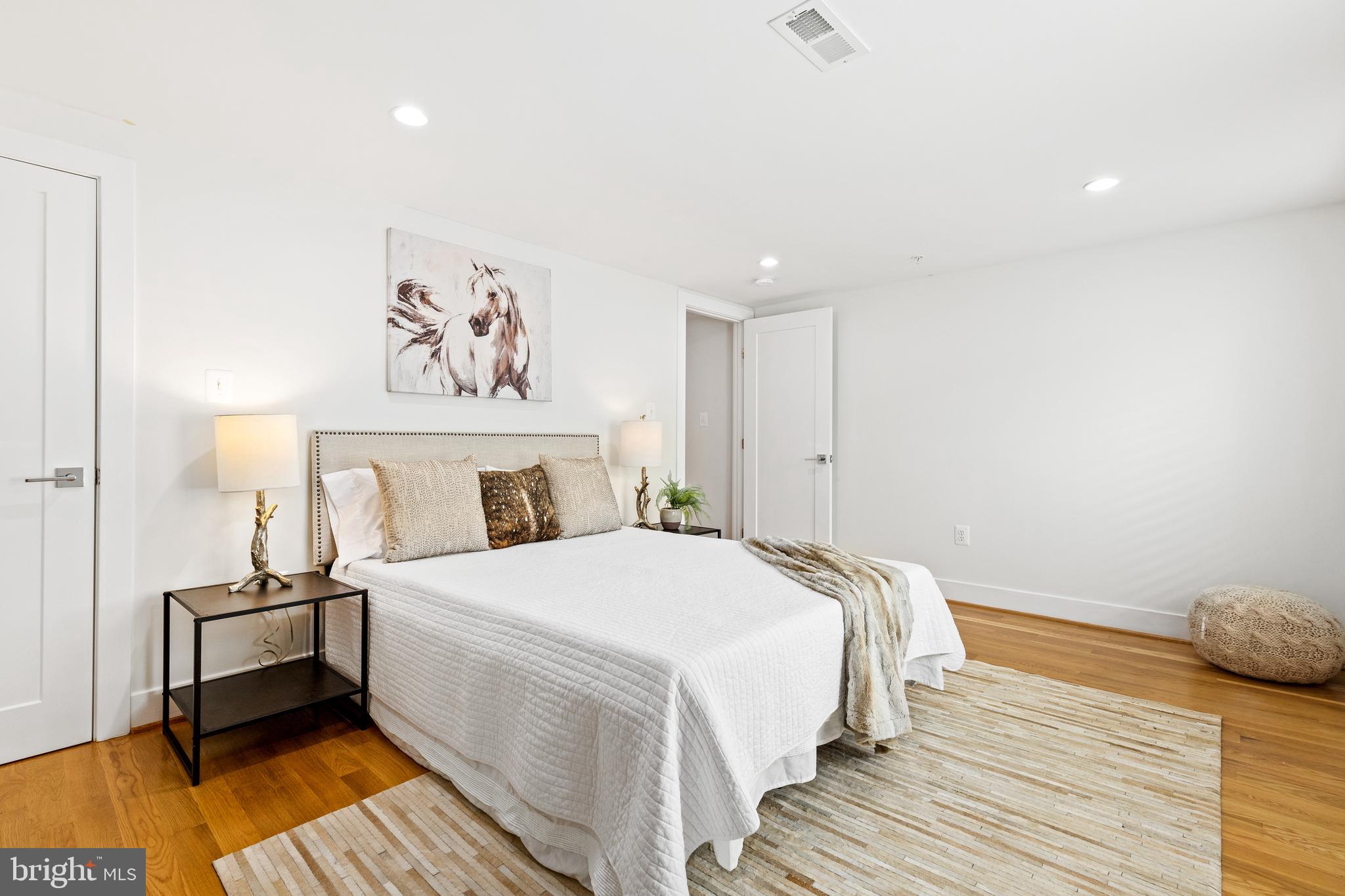 1337 Spring Road Northwest, Unit 1 Washington, DC 20010 - Photo 29 of 39 a bedroom with a bed and wooden floor