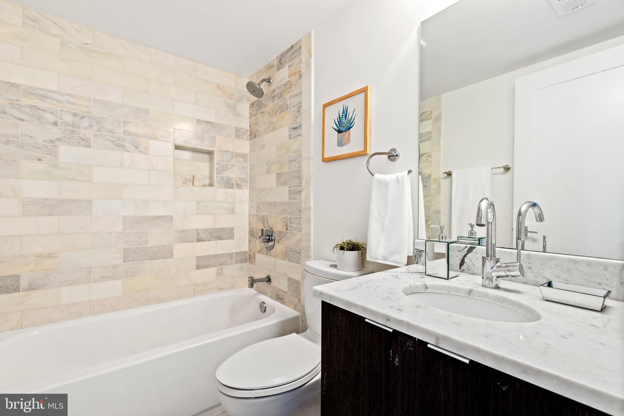1337 Spring Road Northwest, Unit 1 Washington, DC 20010 - Photo 32 of 39 a bathroom with a granite countertop sink a toilet and bathtub