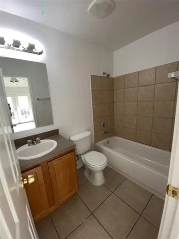 a bathroom with a granite countertop sink mirror vanity and toilet