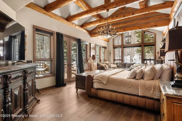 a bedroom with furniture and large windows