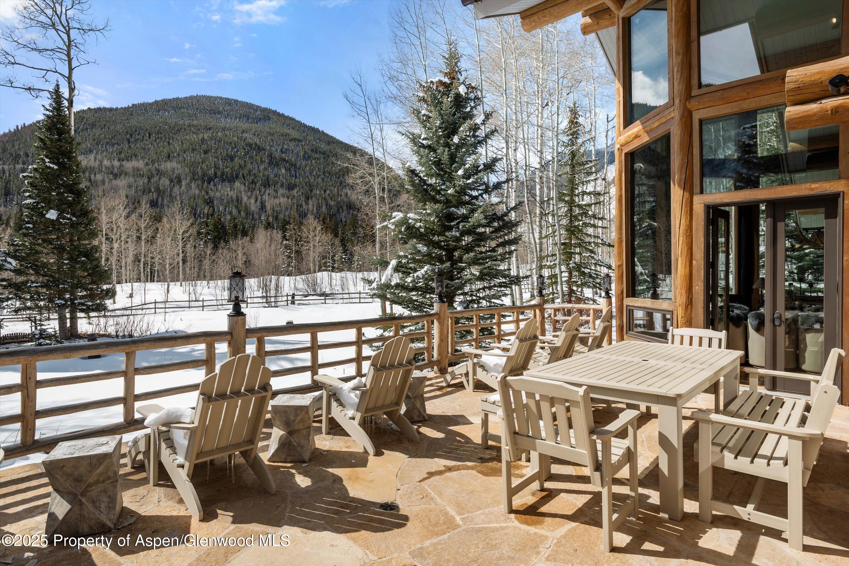 303 Conundrum Creek Road Aspen, CO 81611 - Photo 33 of 39 a view of a patio with table and chairs with wooden floor and fence