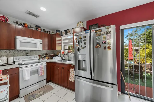 a kitchen with stainless steel appliances granite countertop a refrigerator and a sink