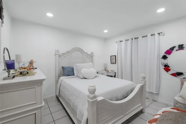 a bedroom with a white bed and a dresser