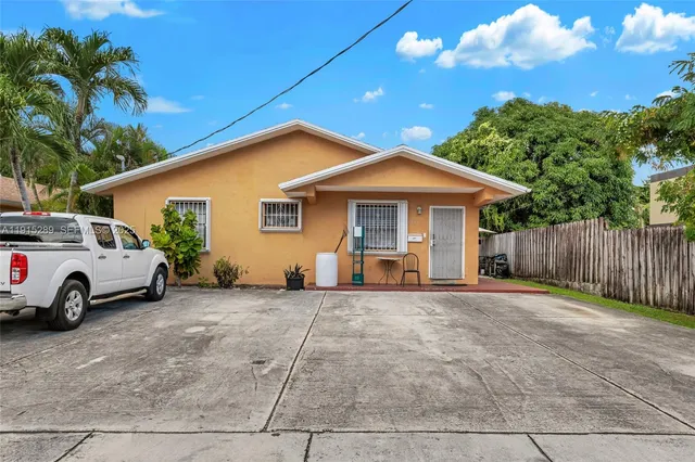 a view of a house with backyard and trees