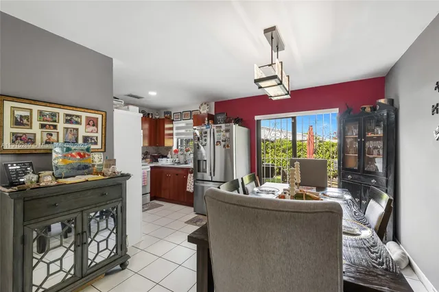 a room with kitchen island stainless steel appliances furniture a chandelier open kitchen view