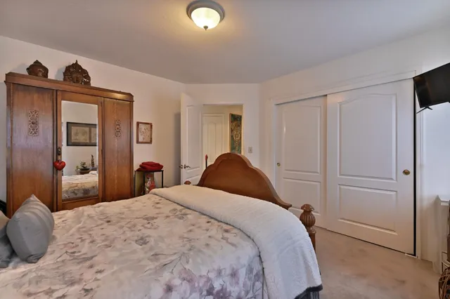 a bedroom with a bed and a flat tv screen