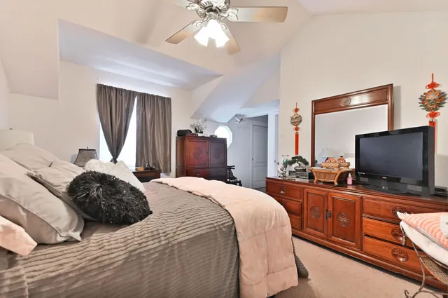 a bedroom with a bed and a flat tv screen on dresser