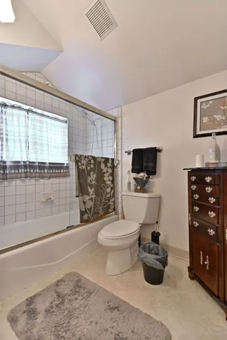 a living room with furniture a flat screen tv and a toilet