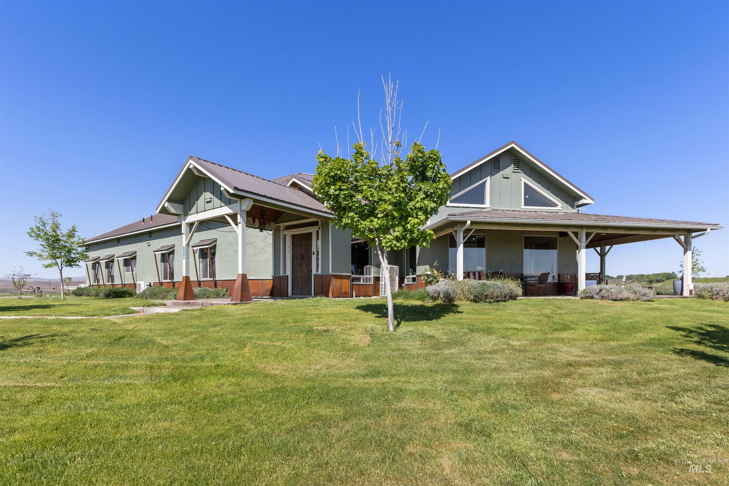 Contemporary home with a large front lawn, covered porch, and extensive covered patio