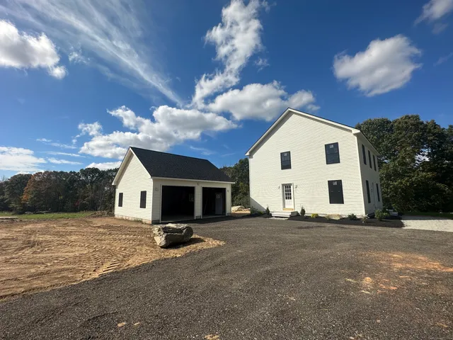 a view of a house with backyard and trees