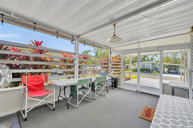 a dining room with wooden floor a chandelier a glass table and chairs