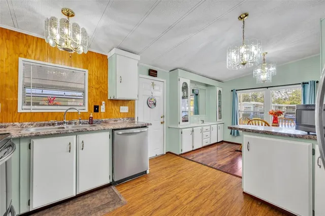 a view of a dining room with furniture a chandelier and wooden floor