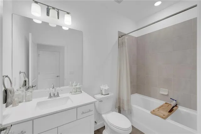 a bathroom with a sink toilet vanity and shower