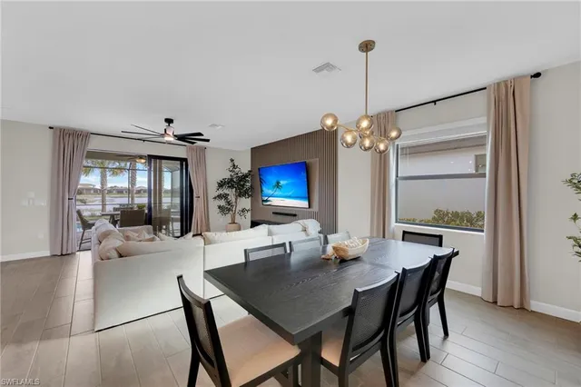 a kitchen with stainless steel appliances kitchen island a table chairs sink and cabinets