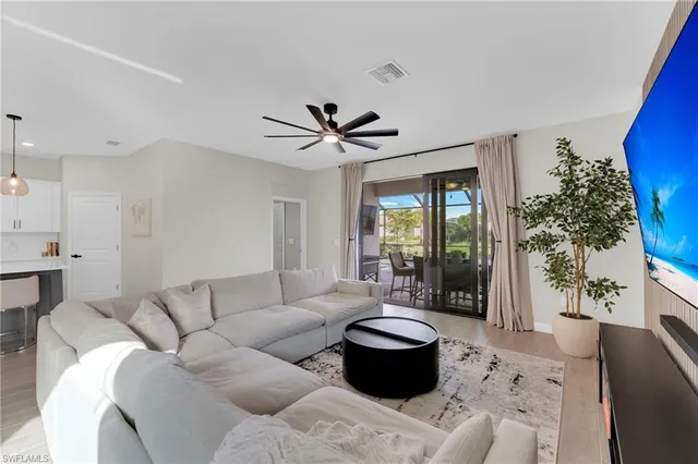 a kitchen with stainless steel appliances a stove a sink a refrigerator and white cabinets with wooden floor