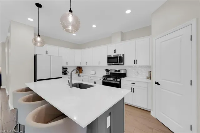 a kitchen with refrigerator a table and chairs