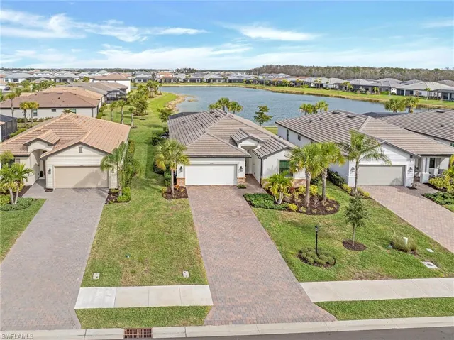 a bedroom with a large bed and a chandelier fan