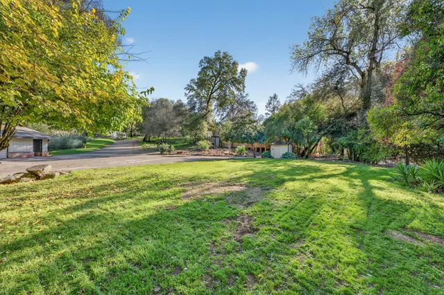a backyard of a house with lots of green space and fountain