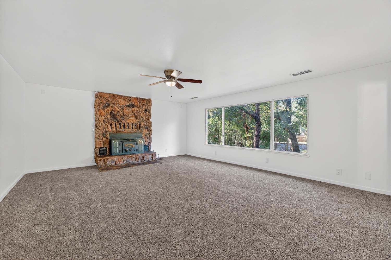 8040 Gilardi Road Newcastle, CA 95658 - Photo 6 of 23 an empty room with windows and chandelier fan