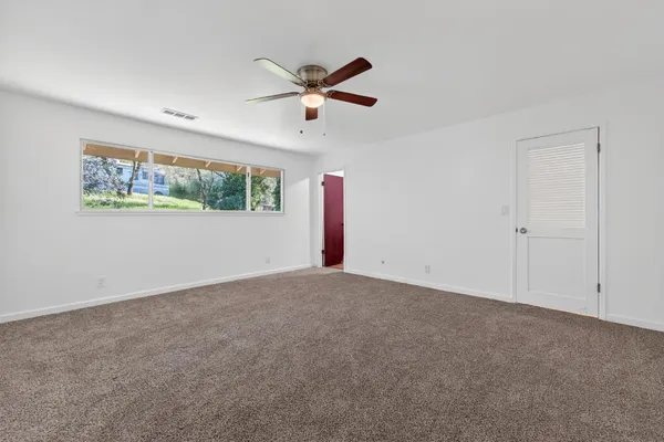 a view of a livingroom with a ceiling fan and window