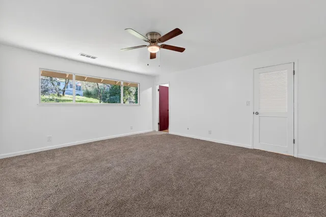 a view of a livingroom with a ceiling fan and window
