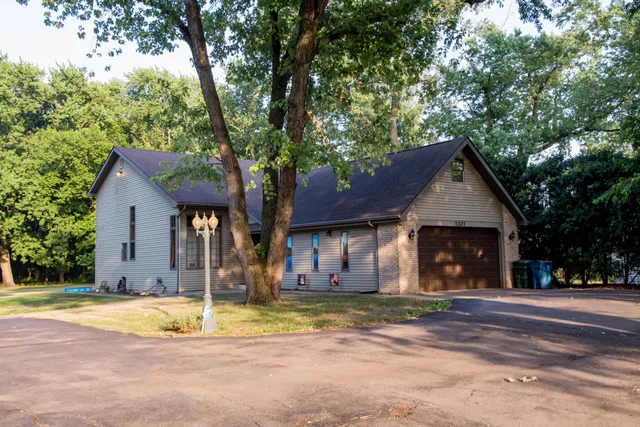 a front view of a house with a yard and trees