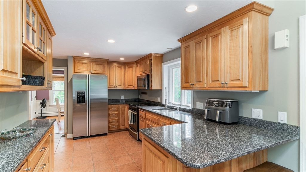 142 Baker Street Walpole, MA 02081 - Photo 11 of 42 a kitchen with stainless steel appliances granite countertop a sink a stove and a wooden cabinets