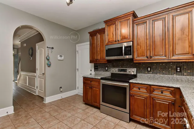 a kitchen with stainless steel appliances granite countertop a stove and a microwave oven with cabinets