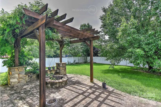 a view of a house with backyard and a tree