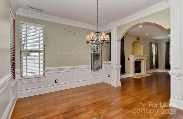 a view of a livingroom with a chandelier fireplace and wooden floor