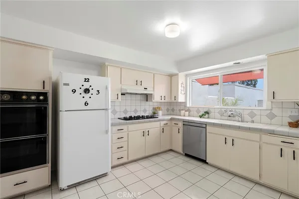 a kitchen with white cabinets and white appliances