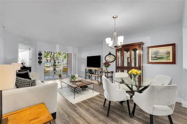 a living room with furniture chandelier and a flat screen tv