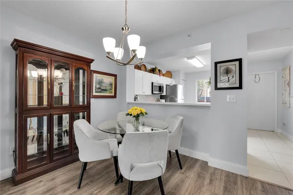 a view of a dining room with furniture a chandelier and wooden floor