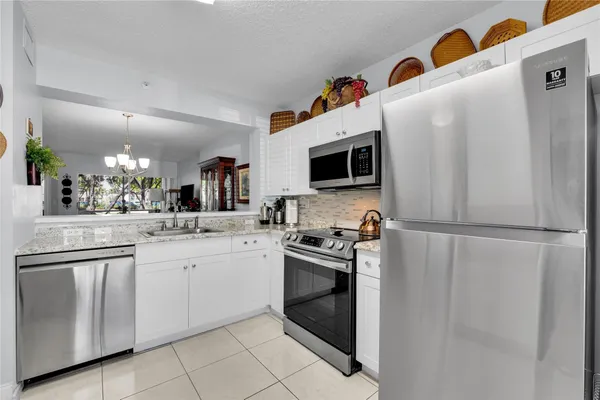 a kitchen with granite countertop cabinets stainless steel appliances and a counter space
