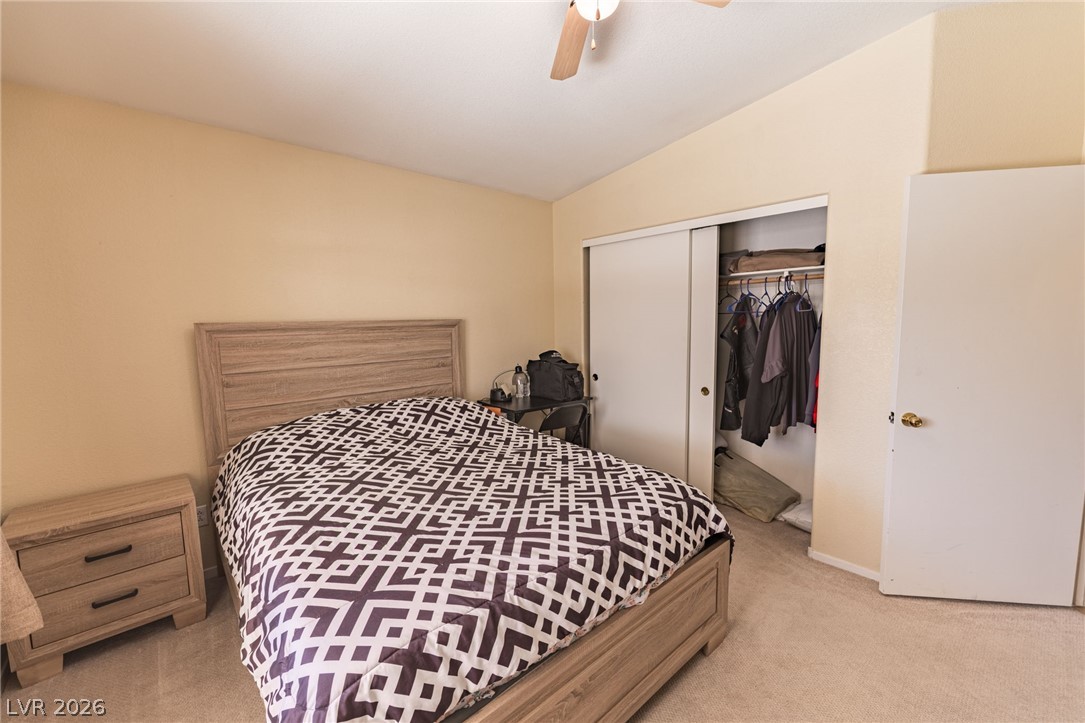 4994 Mascaro Drive Las Vegas, NV 89122 - Photo 8 of 30 A comfortable bedroom with a vaulted ceiling and convenient closet storage.