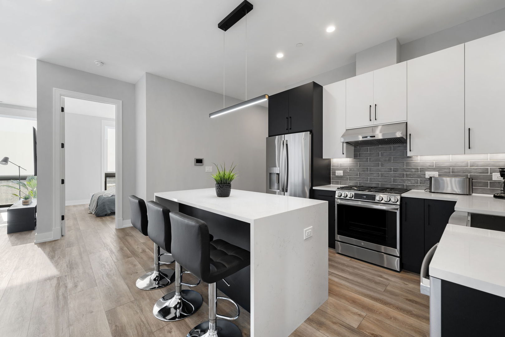 1606 South Ashland Avenue, Unit 401 Chicago, IL 60608 - Photo 2 of 25 a kitchen with a refrigerator a stove and white cabinets with wooden floor