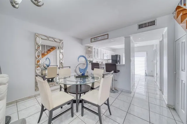 a kitchen with a sink cabinets and dining table chair