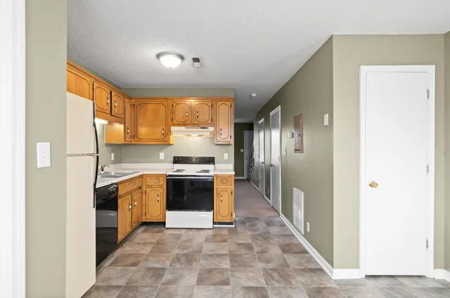 a kitchen with stainless steel appliances granite countertop a refrigerator and a stove