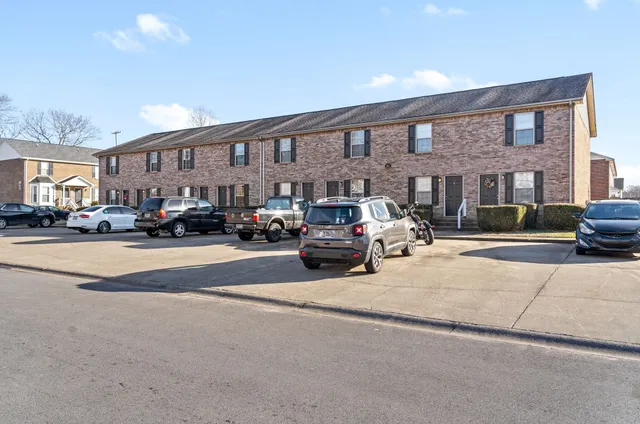 a view of building with cars parked across