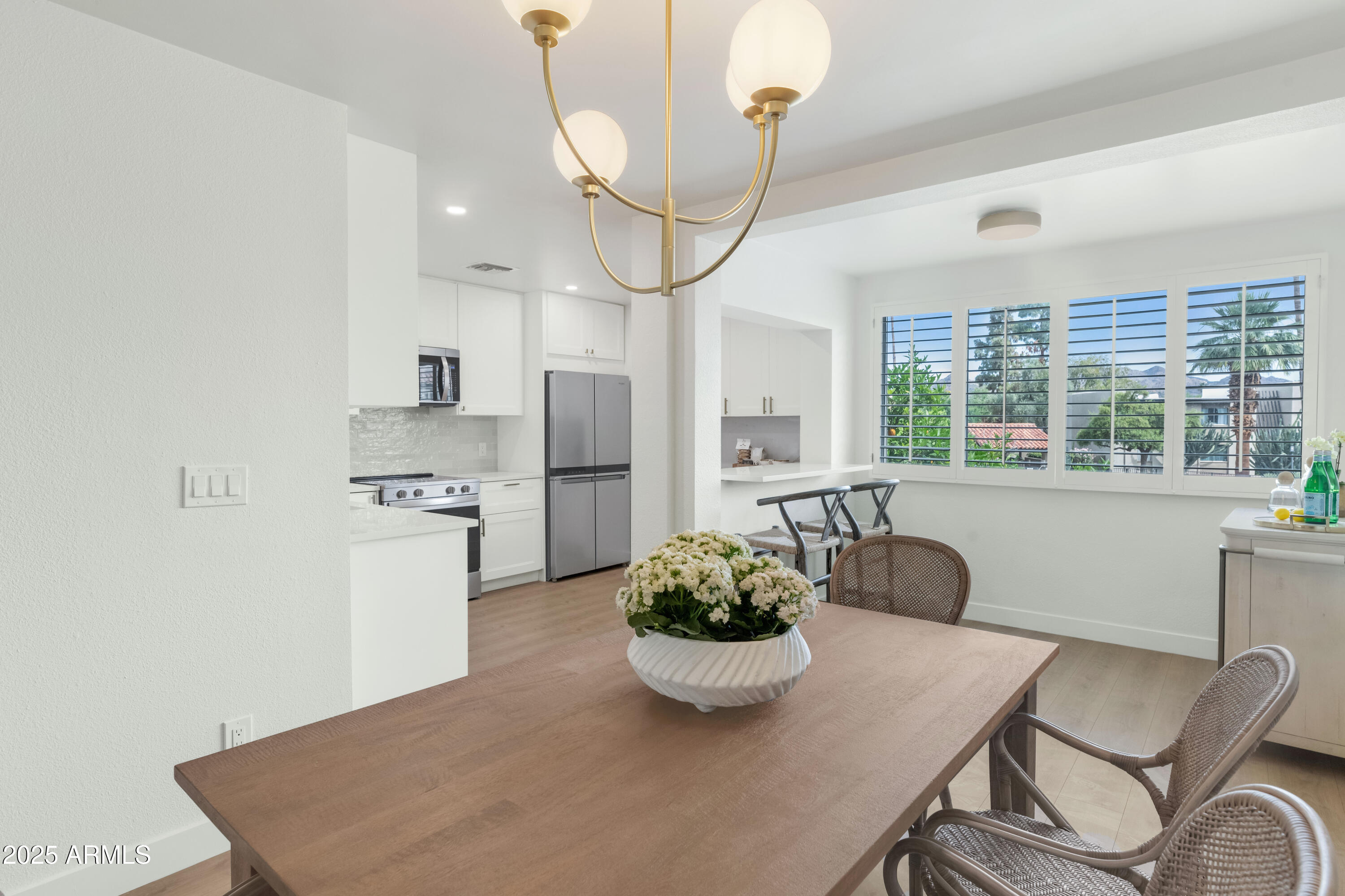 4201 East Camelback Road, Unit 70 Phoenix, AZ 85018 - Photo 1 of 36 a kitchen with stainless steel appliances a dining table chairs and chandelier