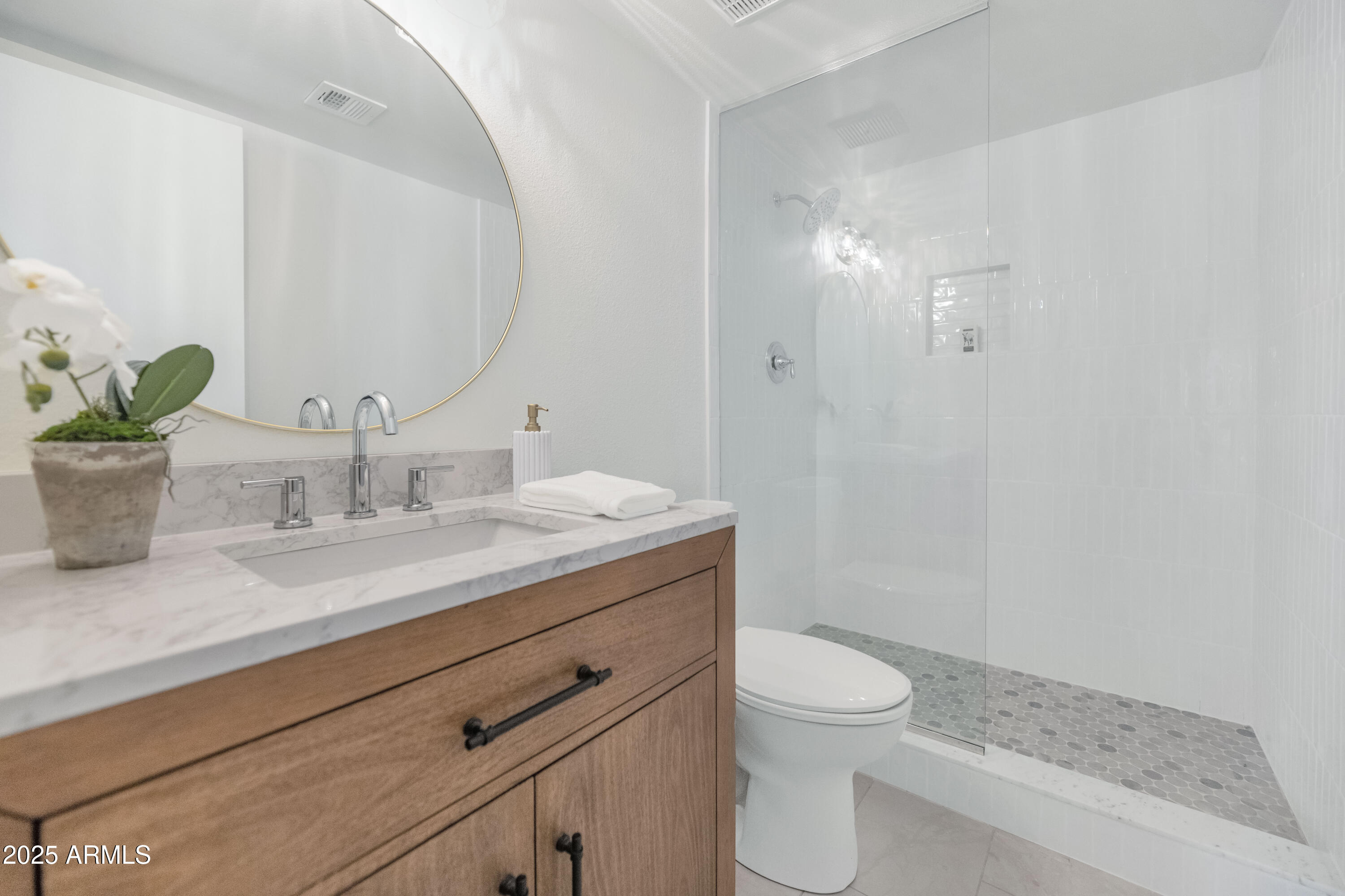 4201 East Camelback Road, Unit 70 Phoenix, AZ 85018 - Photo 25 of 36 a bathroom with a granite countertop toilet a sink and a mirror