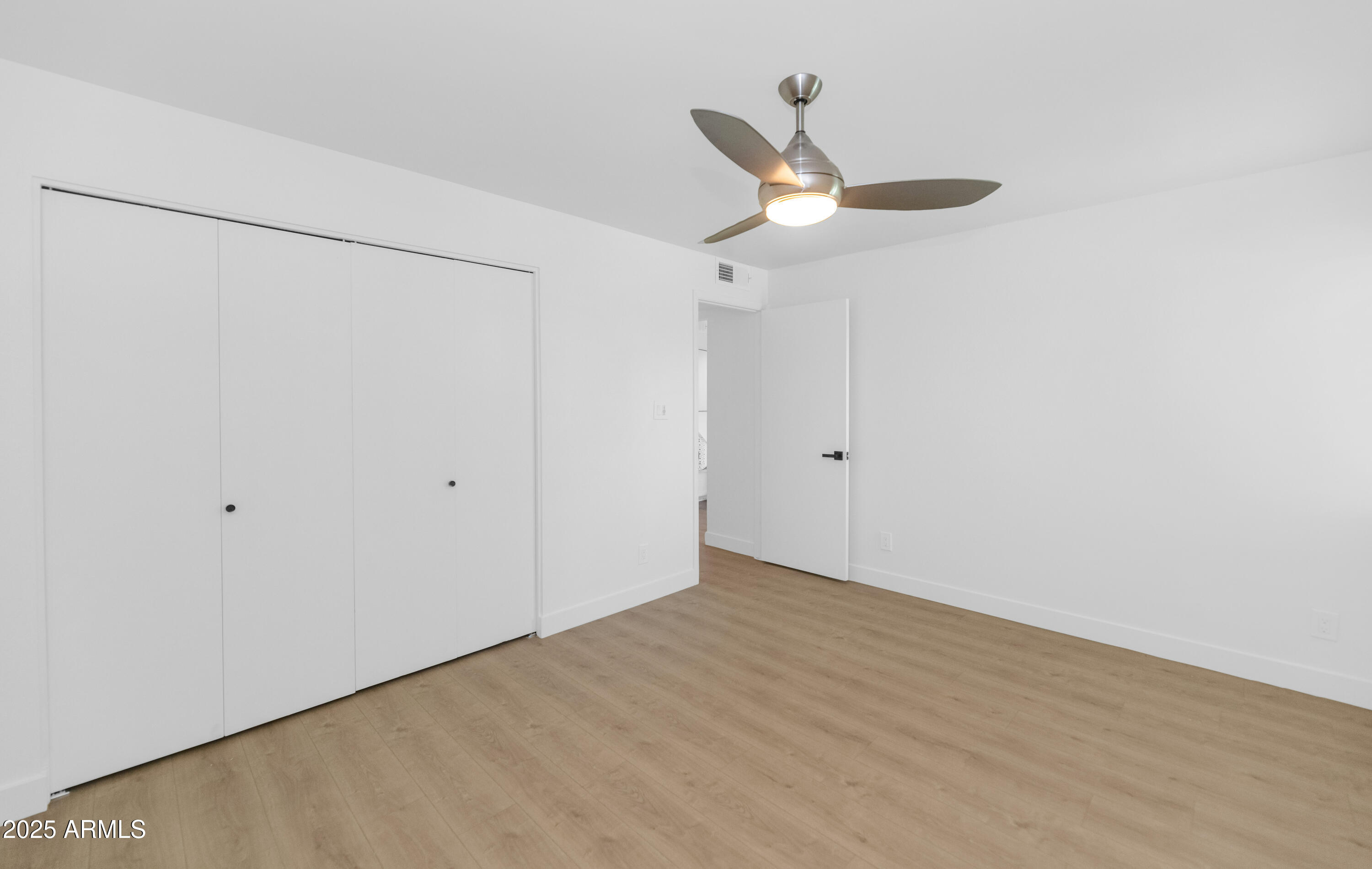 4201 East Camelback Road, Unit 70 Phoenix, AZ 85018 - Photo 27 of 36 an empty room with a ceiling fan and carpet