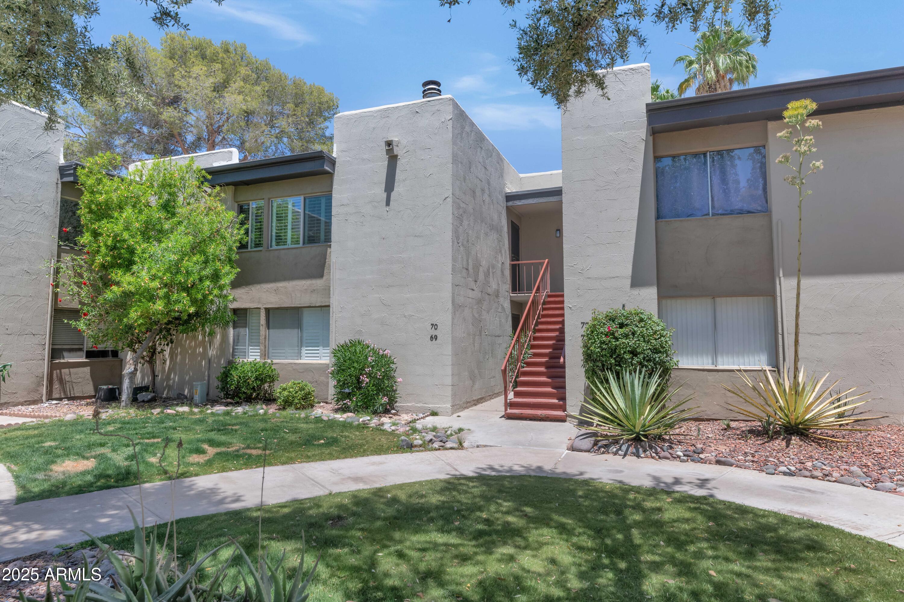 4201 East Camelback Road, Unit 70 Phoenix, AZ 85018 - Photo 32 of 36 a front view of a house with a yard and potted plants