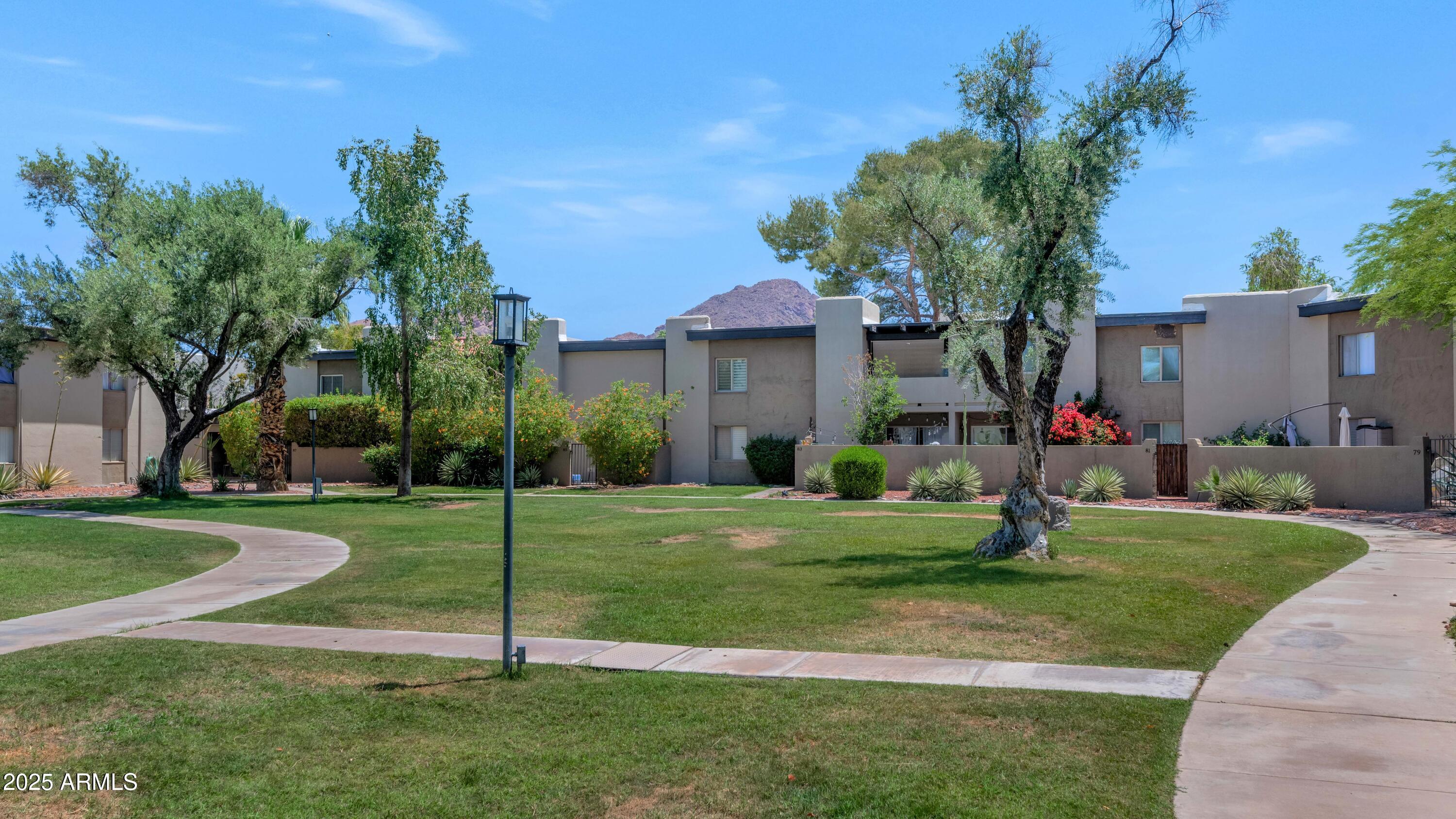 4201 East Camelback Road, Unit 70 Phoenix, AZ 85018 - Photo 36 of 36 a view of a house with a big yard and palm trees