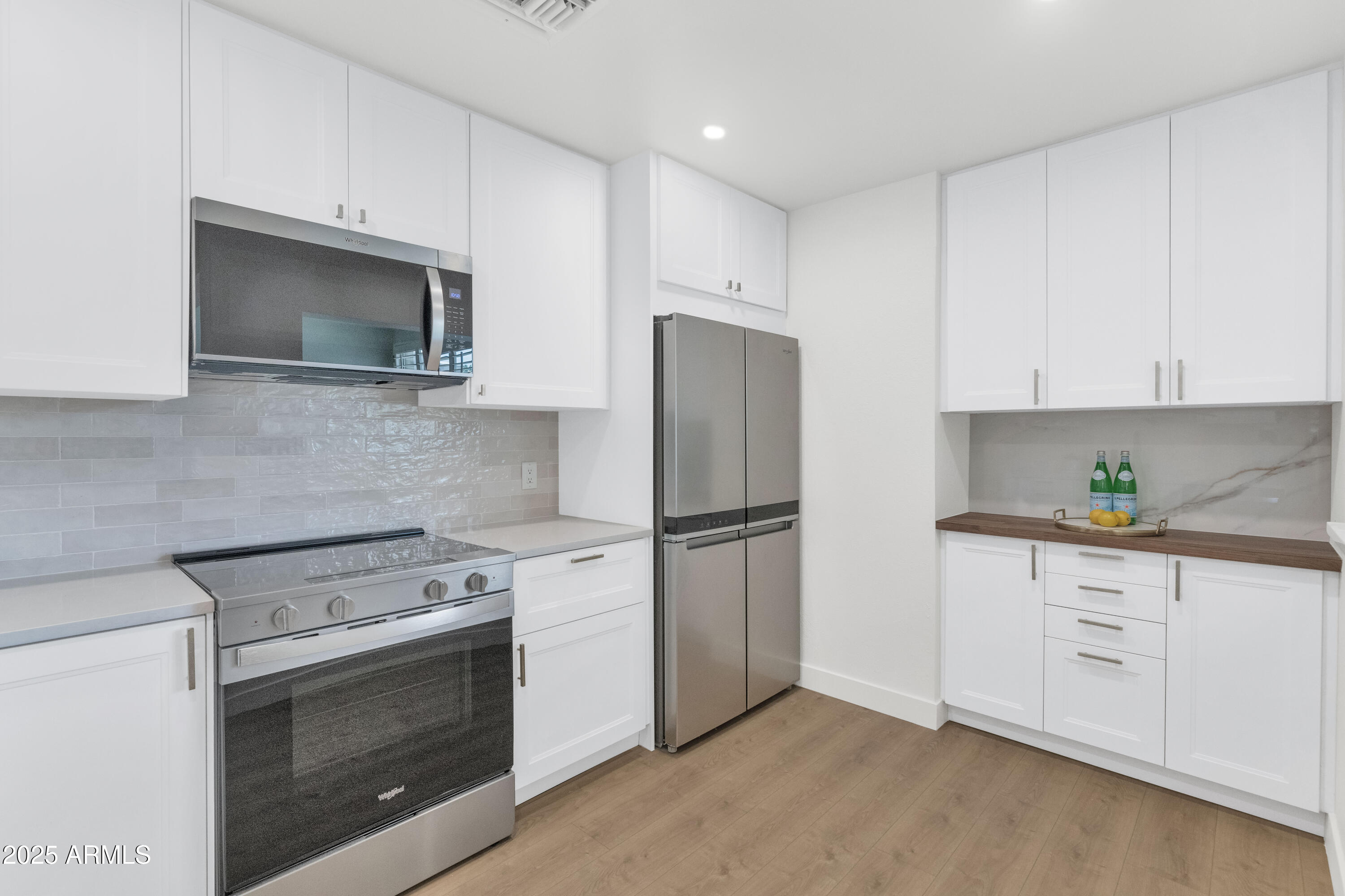 4201 East Camelback Road, Unit 70 Phoenix, AZ 85018 - Photo 4 of 36 a kitchen with white cabinets and stainless steel appliances